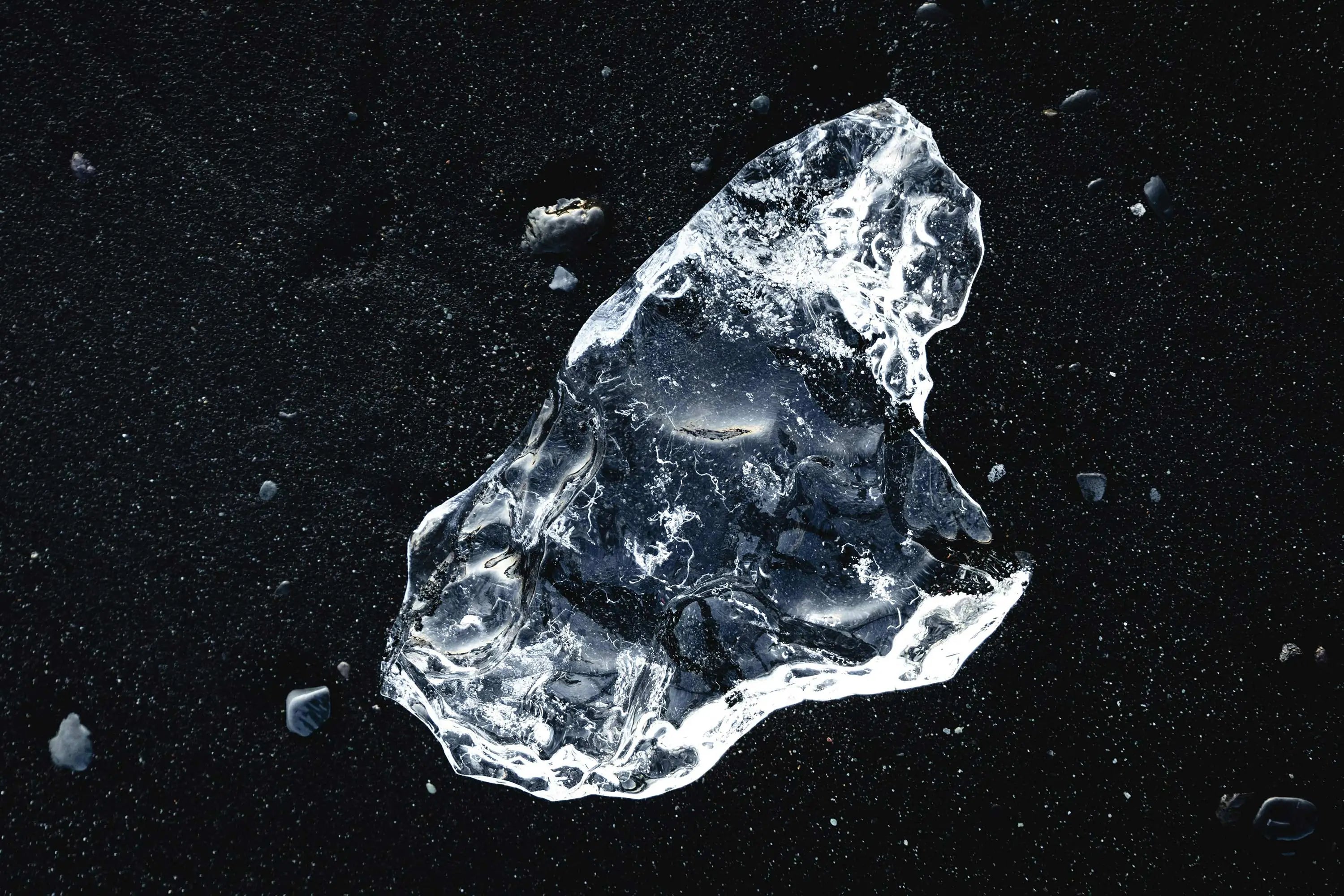 a irregular ice cube placed on the black surface