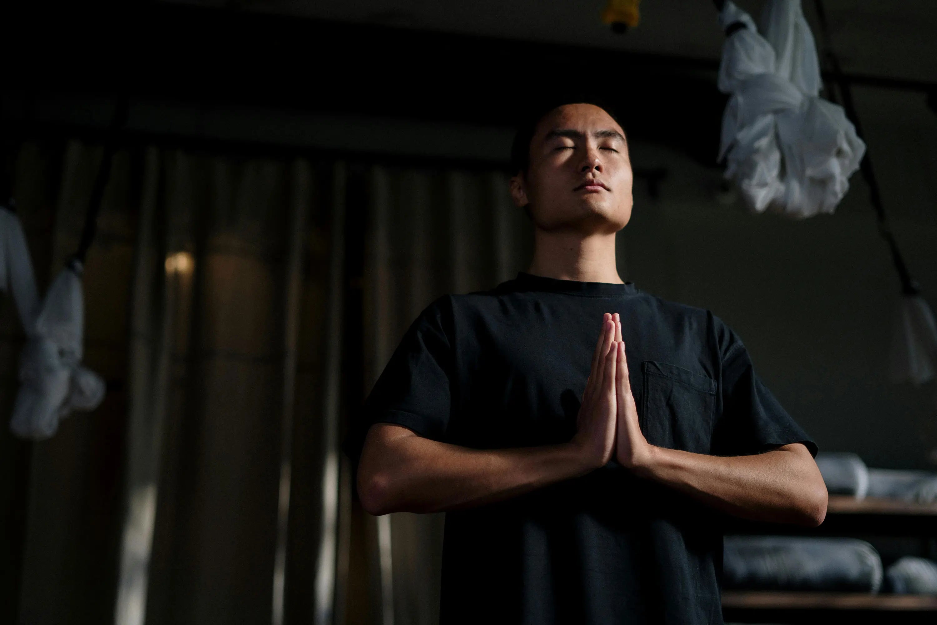 a man standing with his hands connected in meditation